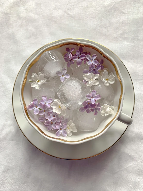 a cup filled with ice and purple flowers, by Hermione Hammond, in style of thawan duchanee, vintage inspired, mid-20s, floating objects