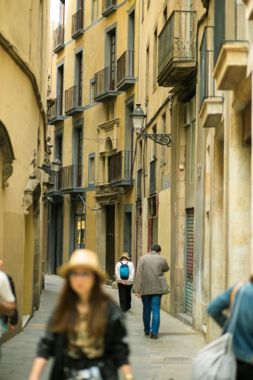 a group of people walking down a narrow street, gothic quarter, photograph, yellow, as photograph