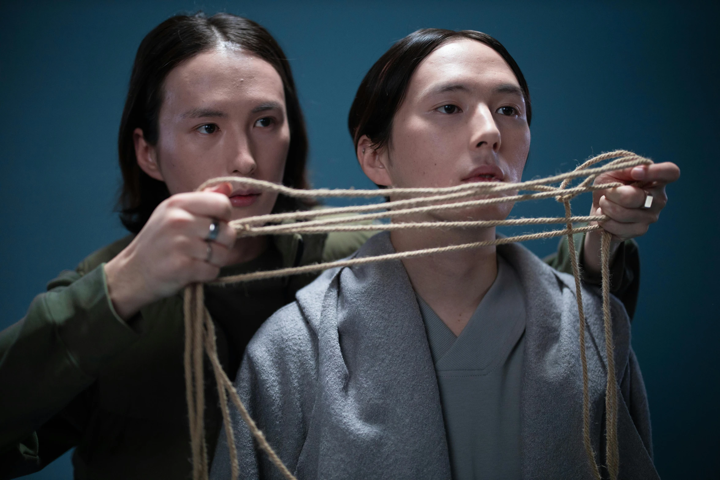 a couple of people standing next to each other, an album cover, inspired by Fei Danxu, conceptual art, rope bondage, actor, weaving, taken with sony alpha 9