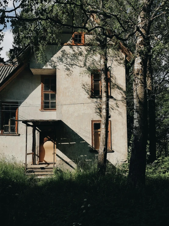 a white house sitting in the middle of a forest, an album cover, by Emma Andijewska, pexels contest winner, modernism, old building, russian style, 1990's photo, cottagecore!!