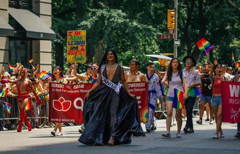 a group of people walking down a street in a parade, by Harriet Zeitlin, pexels contest winner, lgbtq, wearing a tanktop and skirt, miss universe, longque chen