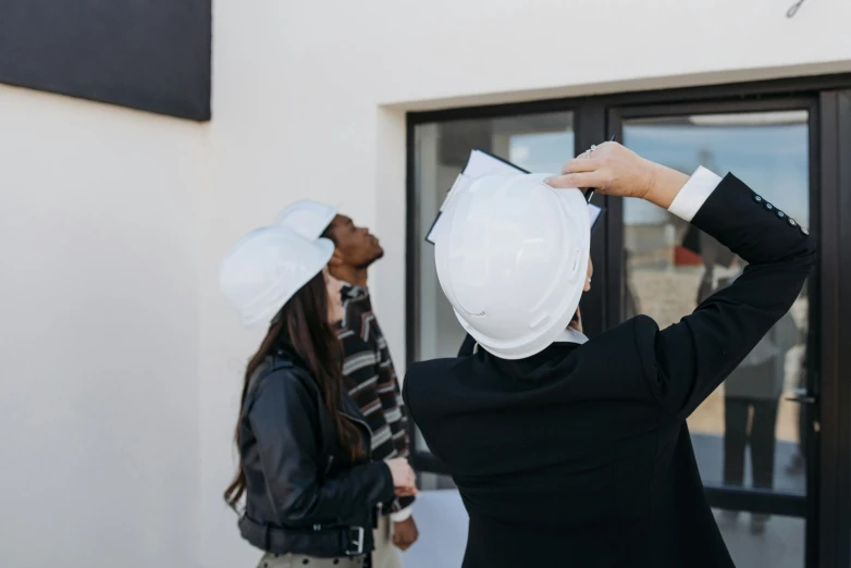 a couple of people that are standing in front of a building, hard hat, profile image, real estate photography, decoration