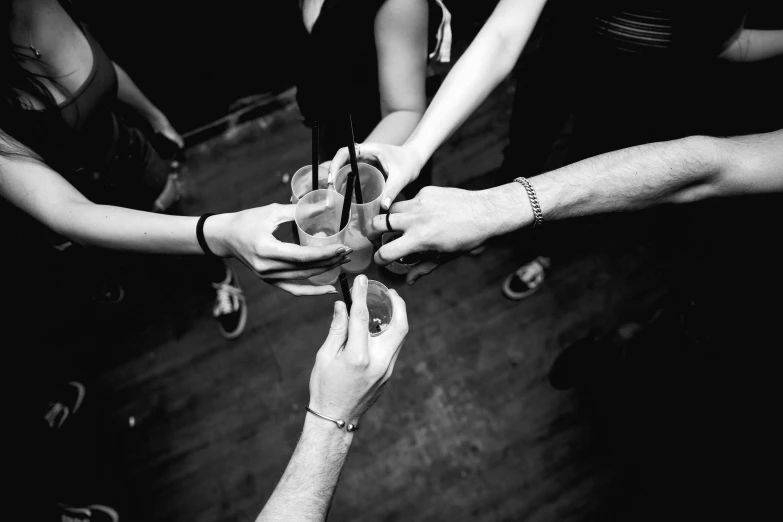 a group of people holding hands in a circle, a black and white photo, pexels, renaissance, holding a martini, ffffound, a wooden, club photography