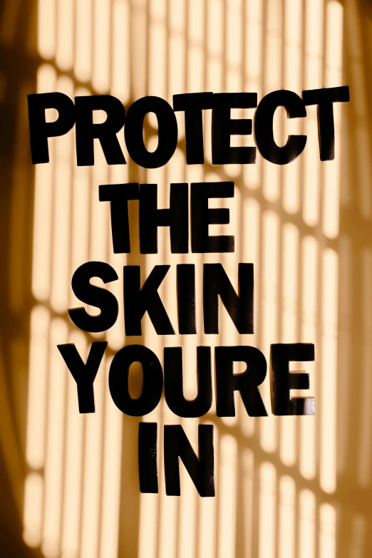 a sign that says protect the skin you're in, poster art, journalism photo, promo image, concern, cut out