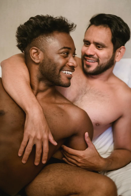 a couple of men sitting on top of a bed next to each other, by Cosmo Alexander, trending on reddit, embracing, diverse colors, hairy torso, promo image