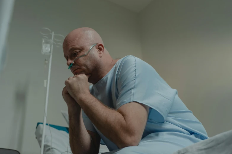 a man sitting in a hospital bed with his hand on his chin, pexels contest winner, kneeling in prayer, 2 0 2 1 cinematic 4 k framegrab, lachlan bailey, surgery theatre