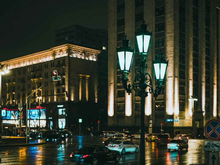 a city street filled with lots of traffic at night, by Adam Marczyński, pexels contest winner, art nouveau, in moscow centre, street light, with stalinist style highrise, gif