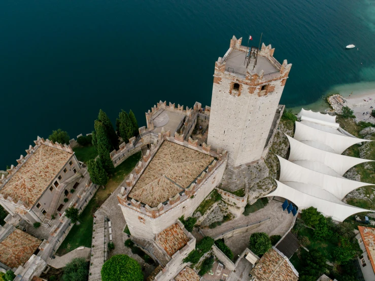 an aerial view of a castle next to a body of water, by Carlo Martini, ivory towers, sky - high view, fan favorite, exterior