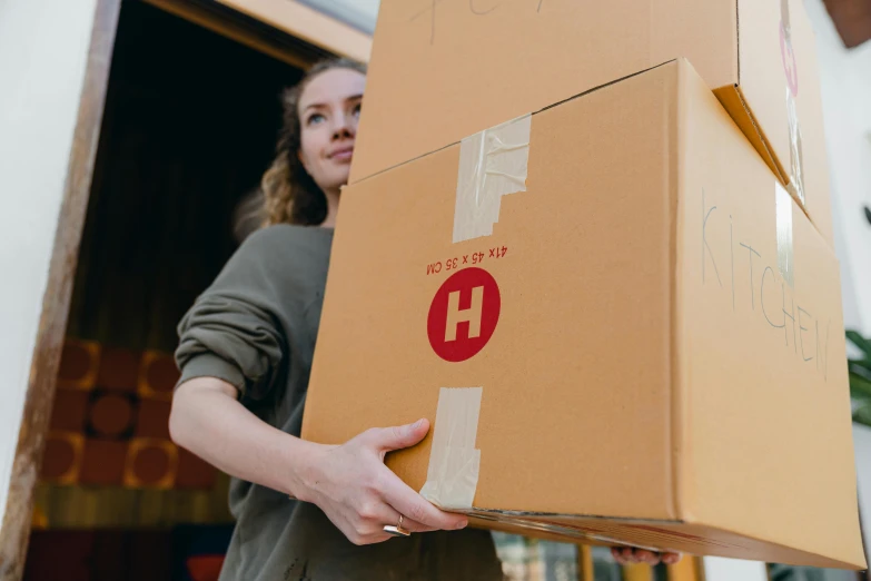 a woman holding a box in front of a moving truck, pexels contest winner, hurufiyya, avatar image, hardware, close up image, exiting store