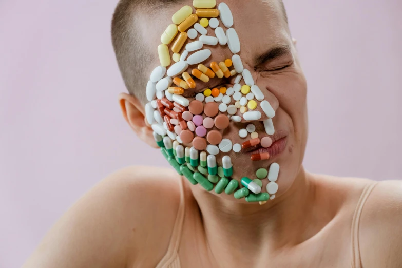 a man with lots of pills on his face, inspired by Damien Hirst, trending on pexels, antipodeans, muscular and exhausted woman, candy treatments, boy with neutral face, lachlan bailey