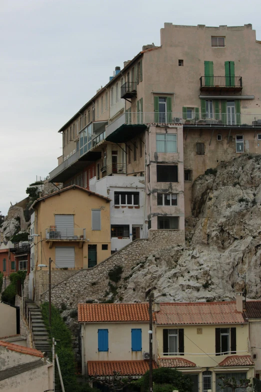 a group of buildings sitting on top of a hill, renaissance, calanque, collapsed floors, view from across the street, balcony