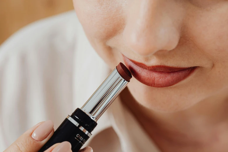 a close up of a person holding a lipstick, featured on cg society, bauhaus, wearing a brown, high quality product image”, full dynamic colour, cherry