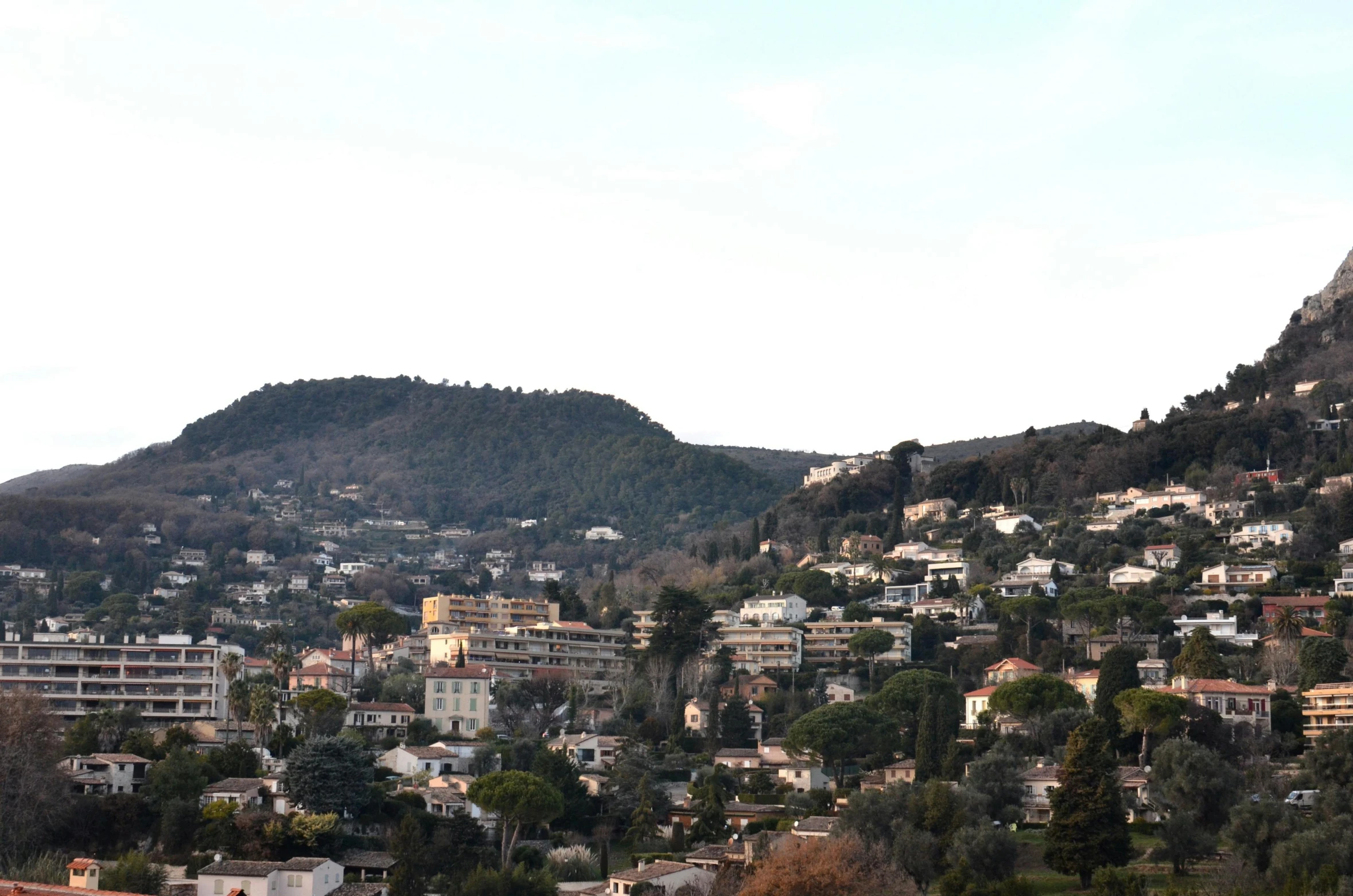 a view of a city with a mountain in the background, pexels, les nabis, hill with trees, nice slight overcast weather, armitage, college