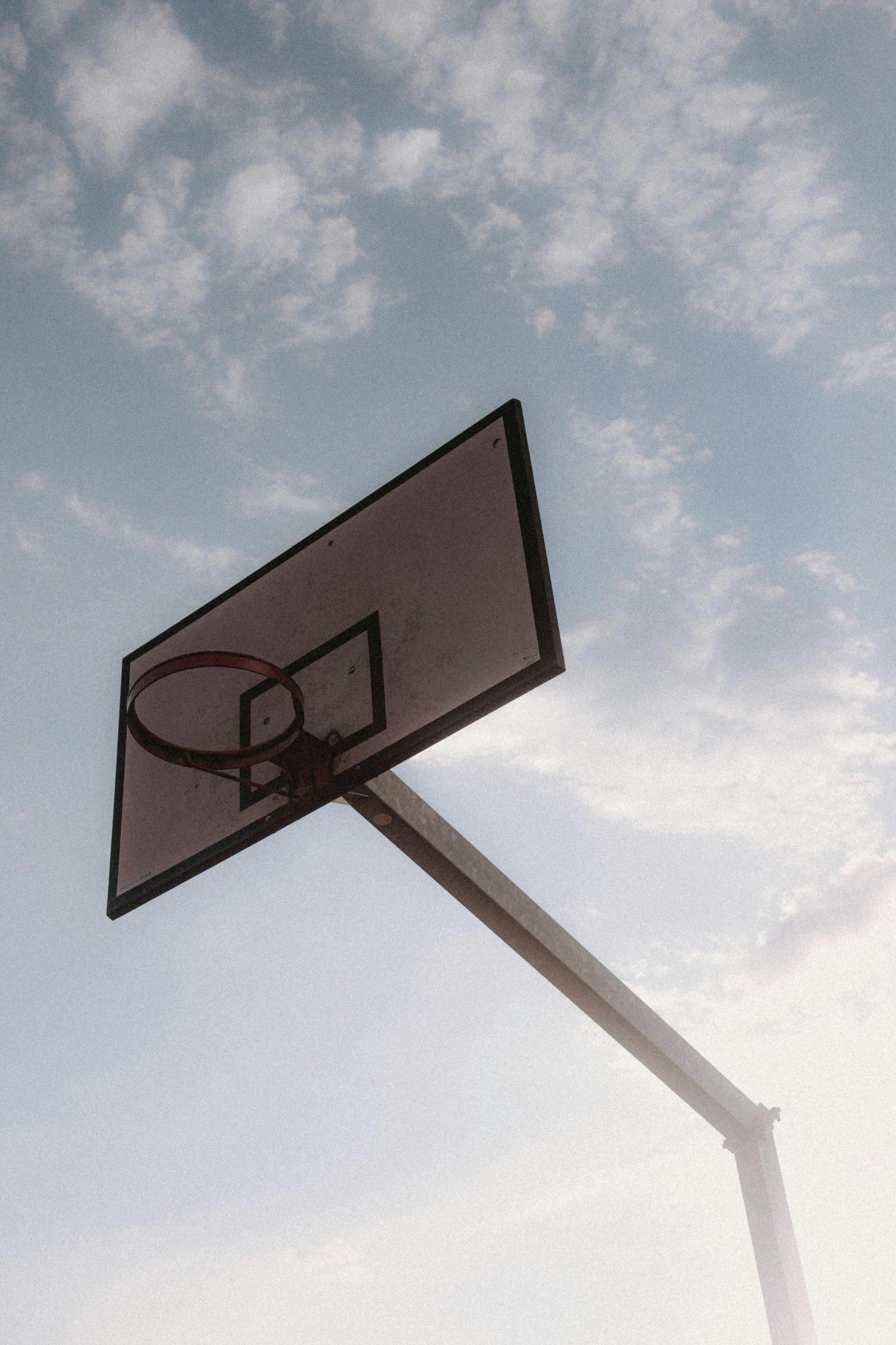 a basketball hoop with a blue sky in the background, an album cover, unsplash, let's play, uniform off - white sky, grainy, single image