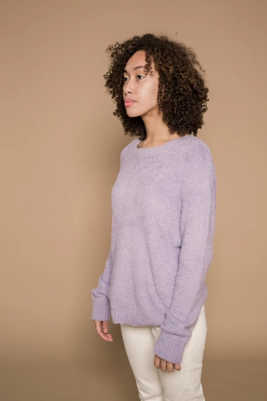 a woman wearing a purple sweater and white pants, a portrait, by Elsie Henderson, trending on unsplash, hurufiyya, pastel texture, very fluffy, plain background, arms to side