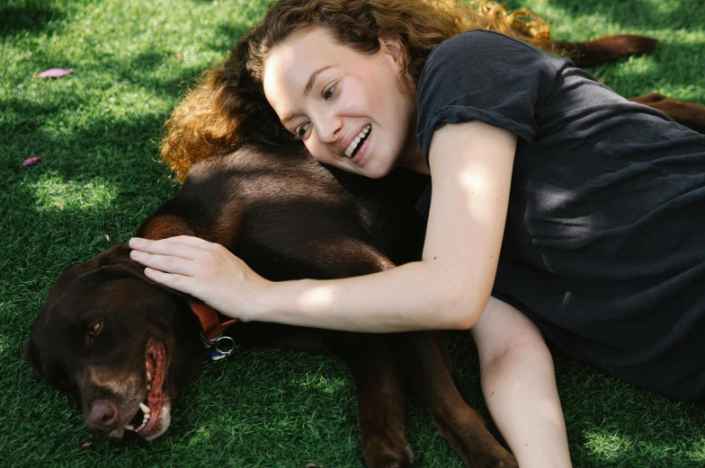 a woman laying on the grass with her dog, pexels contest winner, avatar image, australian, brown, brunette