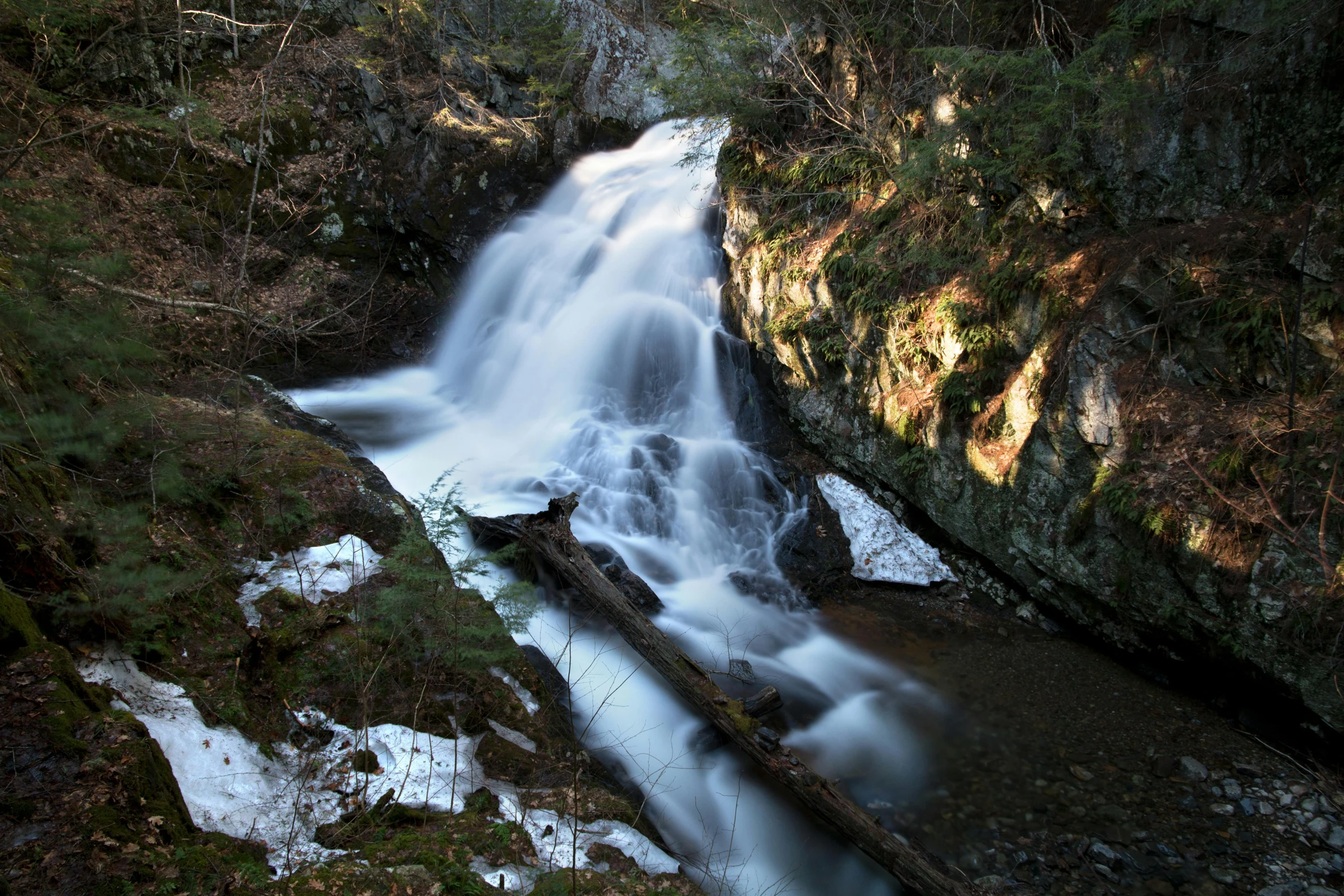 a waterfall in the middle of a forest, by Jim Nelson, unsplash, hurufiyya, fan favorite, winter sun, slow - shutter, ravine