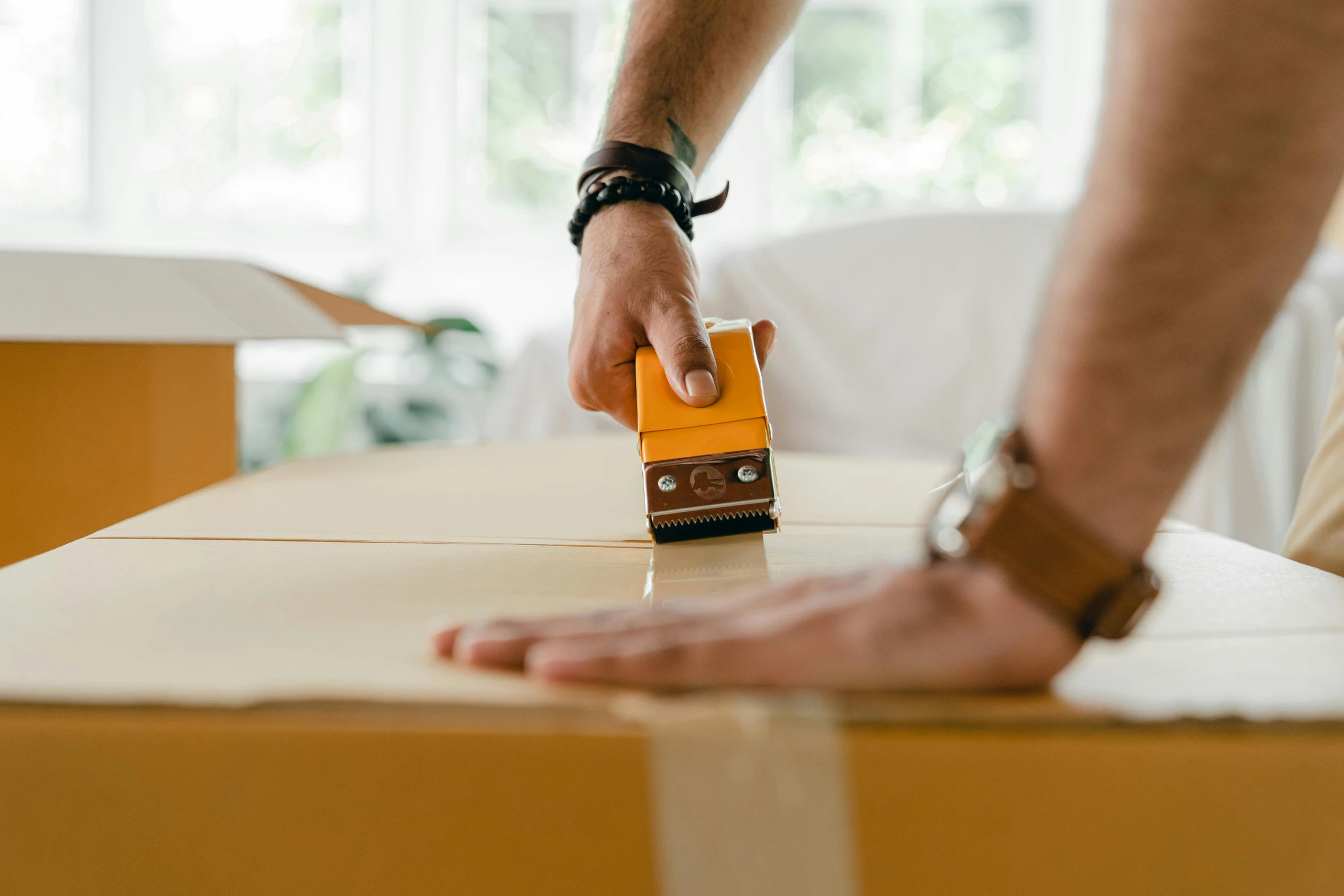 a person putting a piece of cardboard on top of a box, on a table, curved furniture, thumbnail, shot on sony a 7 iii