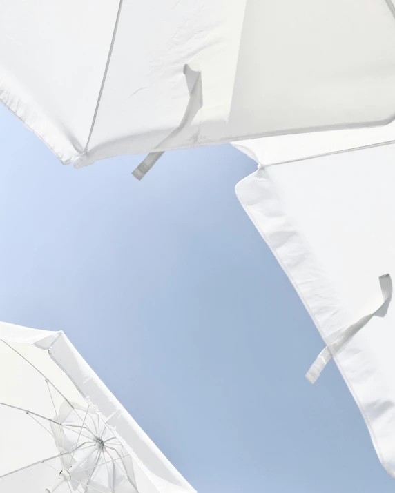 a group of white umbrellas against a blue sky, an album cover, inspired by Cerith Wyn Evans, unsplash, minimalism, white sheets, awnings, detail shot, boats