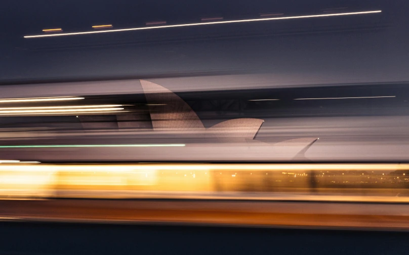 a blurry picture of the sydney opera house at night, a picture, inspired by Zaha Hadid, unsplash contest winner, graffiti, tram, shark, motion, concept photo