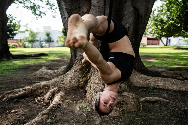 a man doing a handstand in front of a tree, a portrait, by Lee Loughridge, unsplash, arabesque, brunette fairy woman stretching, shibari, sydney park, avatar image