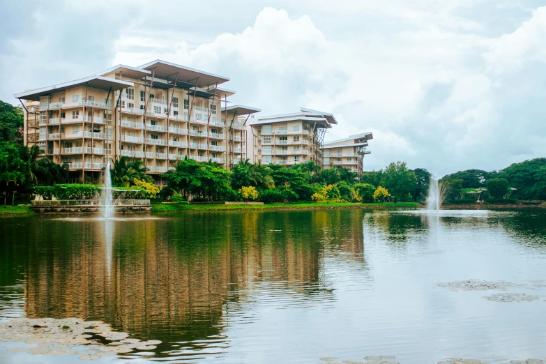 a body of water with a building in the background, resort, woodlands, exterior photo, complex buildings