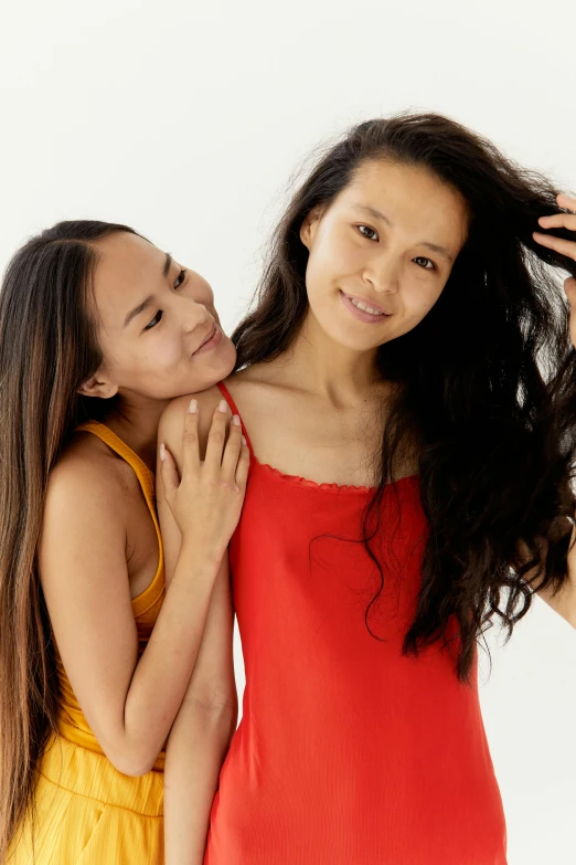 a couple of women standing next to each other, a picture, inspired by Wang Duo, trending on pexels, messy hair bedhead, long thin black hair, playful, intimately holding close