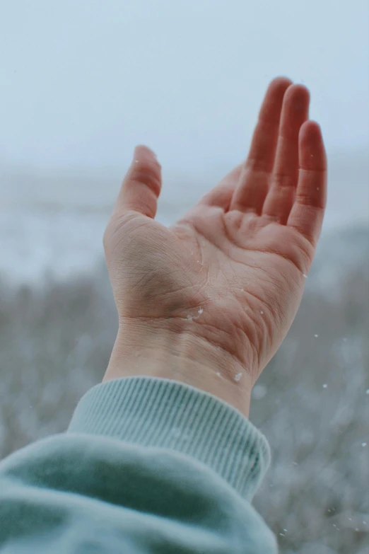 a person holding their hand out in the snow, bubbling skin, promo image, lofi aesthetic, frozen tear