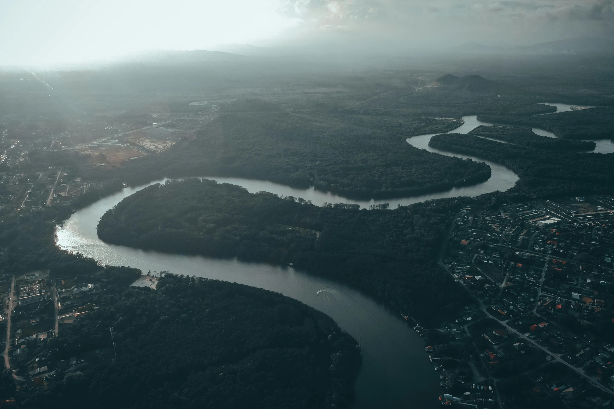 a river running through a lush green valley, by Adam Marczyński, pexels contest winner, aerial view of a city, moody evening light, low quality footage, island floating in the sky