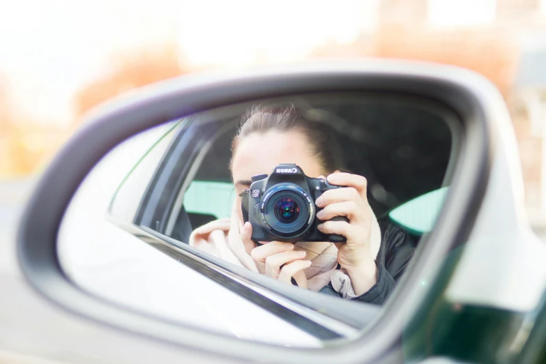 a woman taking a picture of herself in a car mirror, visual art, high-quality dslr photo”