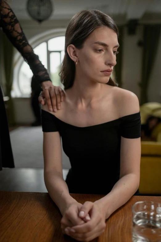 a woman sitting at a table with a glass of water, a portrait, by Adam Marczyński, trending on pexels, renaissance, man grabbing a womans waist, long neck, on a mannequin. high quality, black dress