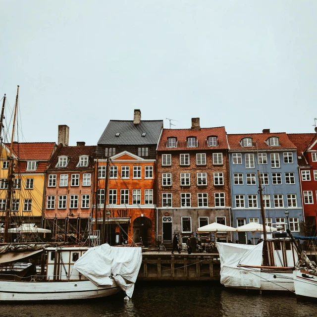 a group of boats sitting on top of a body of water, a colorized photo, by Christen Dalsgaard, pexels contest winner, whitewashed buildings, red brown and grey color scheme, 🦩🪐🐞👩🏻🦳, on a rainy day