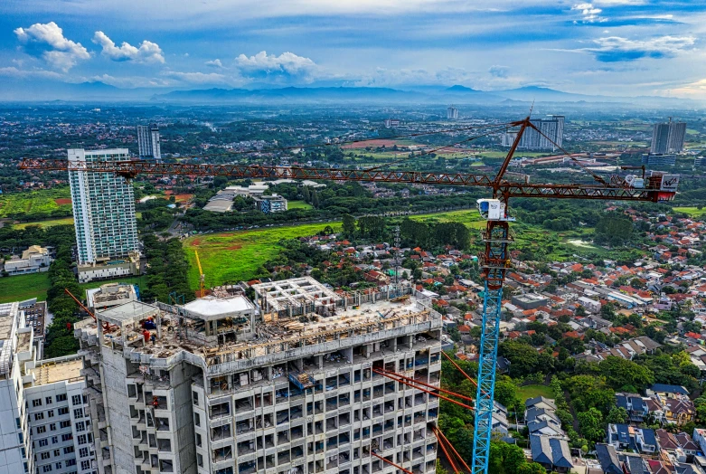 a crane that is standing on top of a building, by Basuki Abdullah, pexels contest winner, hyperrealism, aerial footage, panorama, mixed development, 2 0 2 2 photo