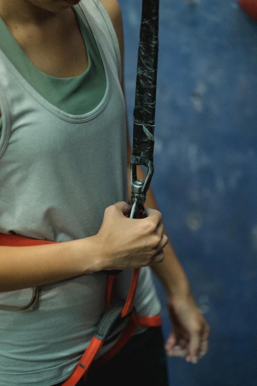 a woman holding a tennis racquet in her hands, by Adam Marczyński, rock climbing, big belt, indoor picture, hoog detail