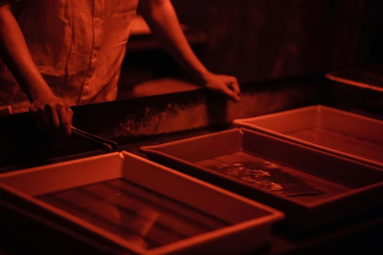 a woman that is standing in front of some boxes, a silk screen, volcanic embers, carefully crafted, glowing red veins, carrying a tray