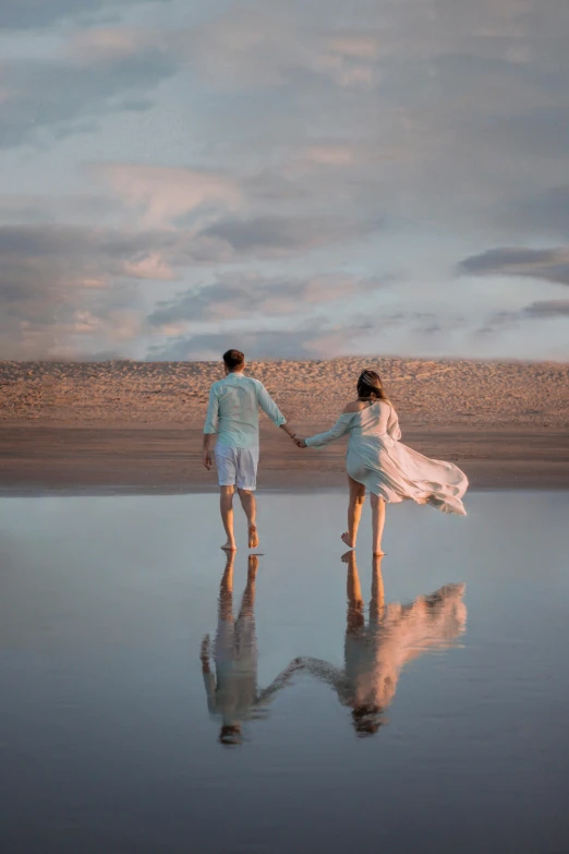 a man and a woman walking on a beach holding hands, by Arabella Rankin, unsplash, romanticism, floating robes, water reflection, pastel hues, watch photo