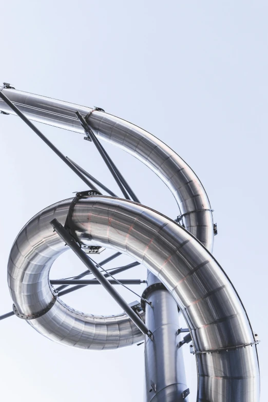 a water slide going down the side of a tall building, an abstract sculpture, by Doug Ohlson, unsplash, steel pipes, super detailed image, playground, turbines