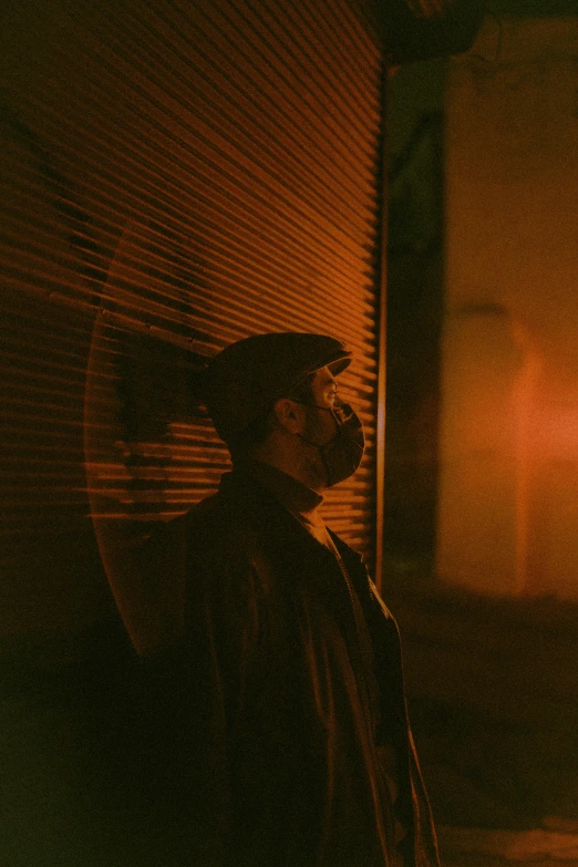 a man standing in front of a building at night, an album cover, pexels contest winner, dark visor covering face, redscale photography, brown atmospheric lighting, ((portrait))