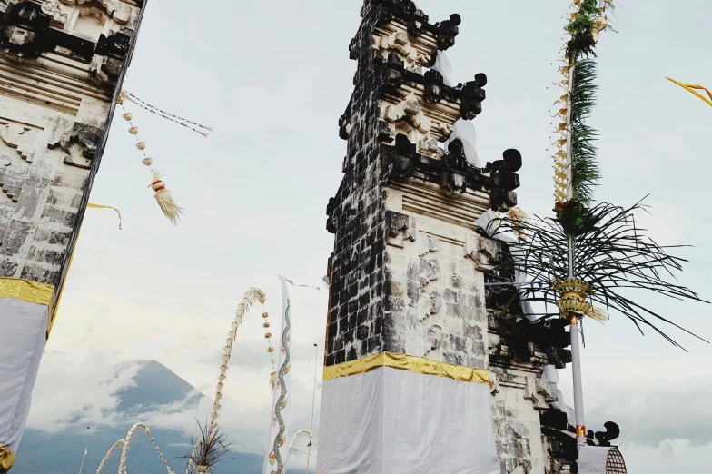 a group of people standing in front of a tall building, by Carey Morris, unsplash contest winner, an altar of a temple, standing close to volcano, decorations, background image