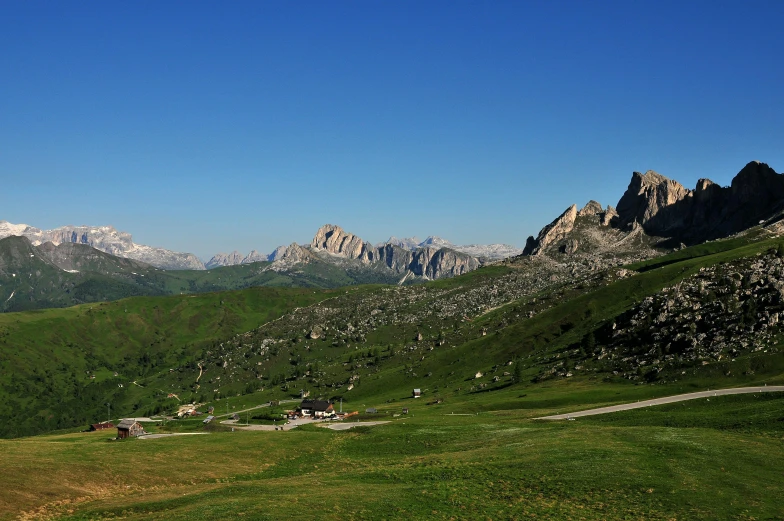 a couple of cows standing on top of a lush green hillside, an album cover, by Giuseppe Grisoni, pexels contest winner, renaissance, lago di sorapis, panorama distant view, high quality screenshot, alpine architecture