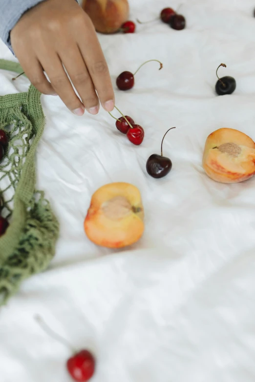 a person picking cherries from a bag on a bed, trending on unsplash, visual art, peach embellishment, white tablecloth, made of food, chiffon