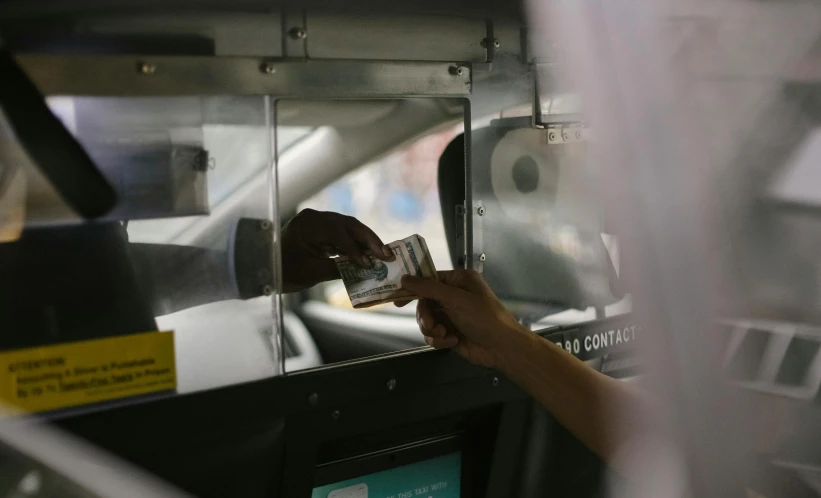 a close up of a person holding a cell phone, at the taco bell drive through, banknote, alessio albi, transparent black windshield