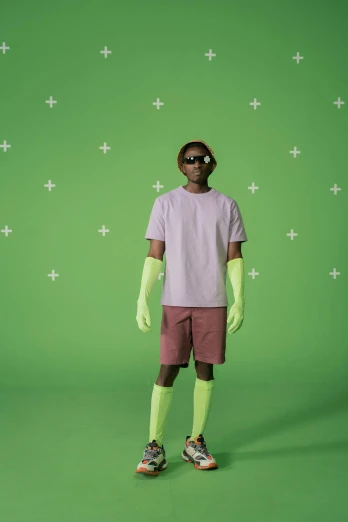 a man standing in front of a green screen, wearing kneesocks, muted neon colors, in style of tyler mitchell, wearing gloves