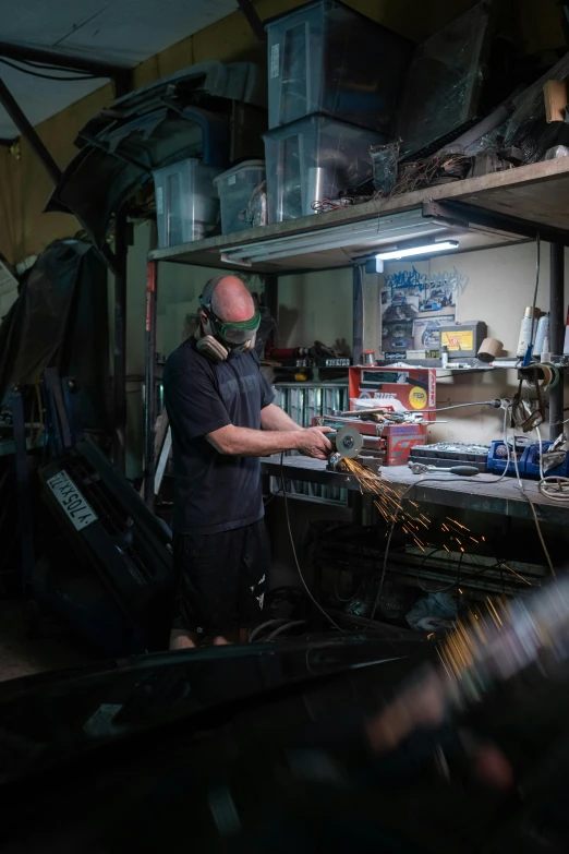 a man that is working on some kind of thing, featured on reddit, metal body, very low light, high quality photo, profile