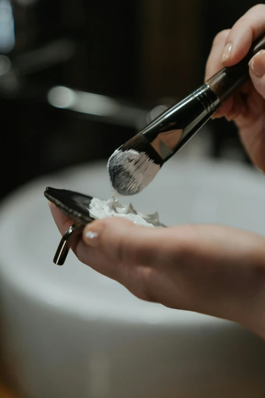 a person shaving their nails with a brush, by Daniel Seghers, white powder makeup, sink, white clay, stainless steal