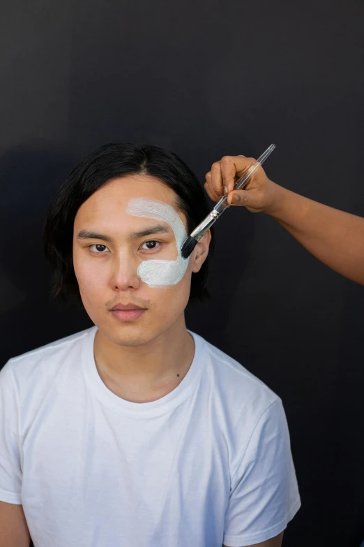 a person cutting another person's hair with scissors, inspired by Russell Dongjun Lu, white facepaint, smooth oval shape face, male model, showing forehead