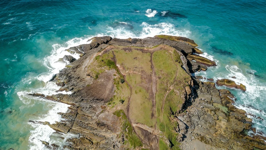 an aerial view of a rock outcropping in the ocean, by Thomas Furlong, pexels contest winner, land art, at an archaeological dig site, te pae, an aerial tennis court, profile image