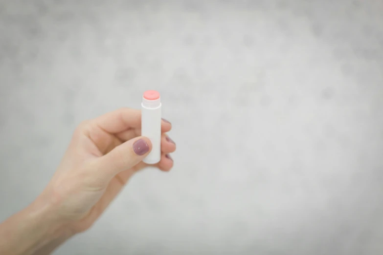 a person holding a pink pill in their hand, by Emma Andijewska, unsplash, coral lipstick, pink white turquoise, copic marker, rectangle