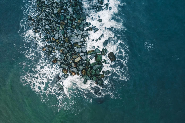 a large body of water next to a rocky shore, pexels contest winner, top-down shot, turbulence, oceanside, multiple stories