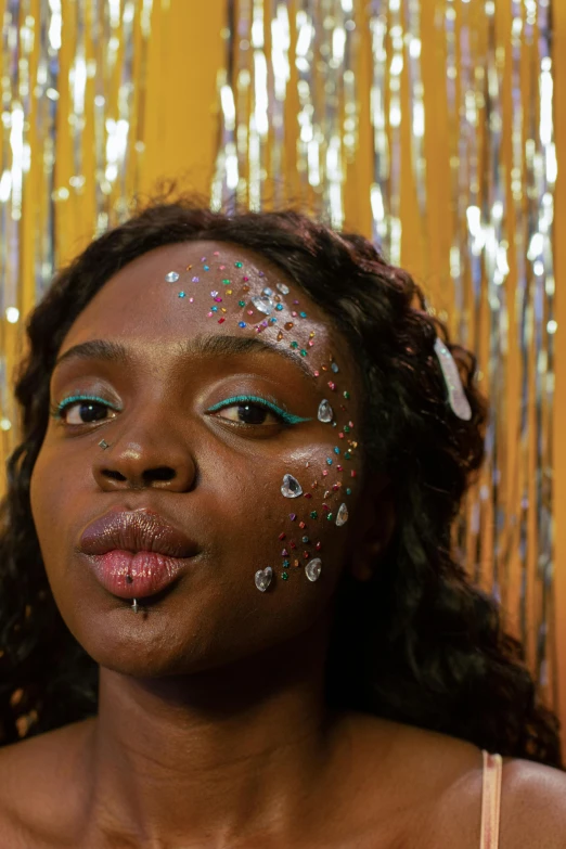 a close up of a woman with glitter on her face, an album cover, by Lily Delissa Joseph, black teenage girl, her iridescent membranes, a plaster on her cheek, 2019 trending photo